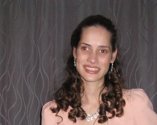 Image of Lucy smiling in her formal dress and pink blazer.