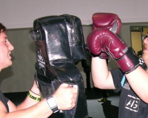 An image of Sam boxing with his Personal Trainer at the gym.