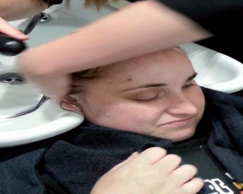 An image of Tamara getting her hair washed by the hairdresser at the salon.